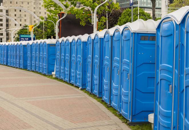 a row of portable restrooms set up for a large athletic event, allowing participants and spectators to easily take care of their needs in Berkshire